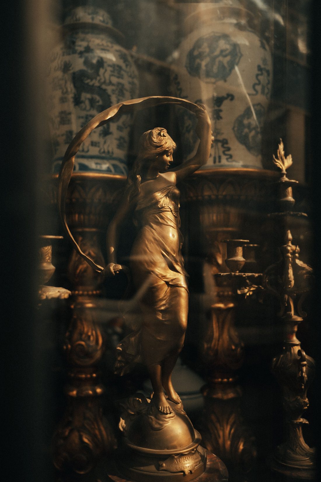 A bronze figure of a woman turning within a ribbon of metal